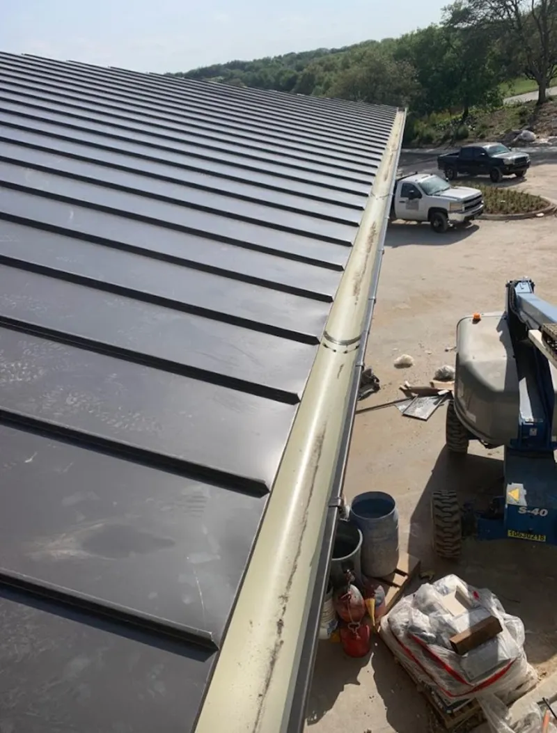 Standing seam panel and gutter detail on a metal roofing jobsite in Freehold